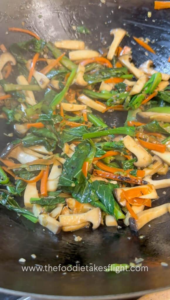 Vegetables and mushrooms stir-fried in a wok before adding gravy