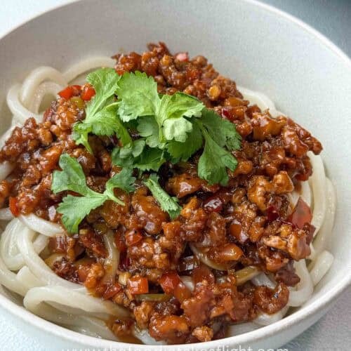 Close-up of chewy Sanuki udon topped with sweet chili calamansi sauce with baked tofu and green chili
