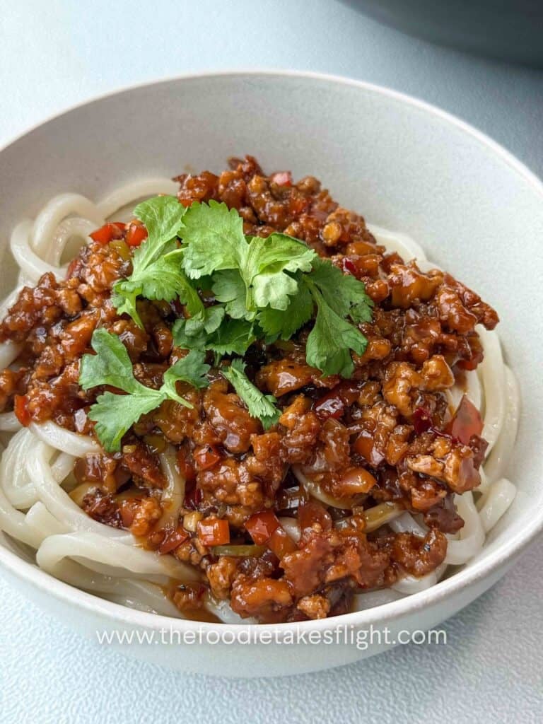 Close-up of chewy Sanuki udon topped with sweet chili calamansi sauce with baked tofu and green chili