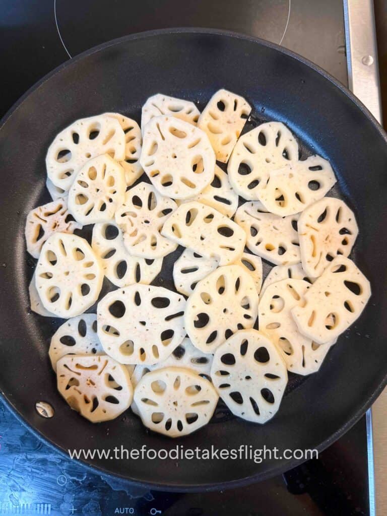 Lotus root browning in a skillet until golden and crisp