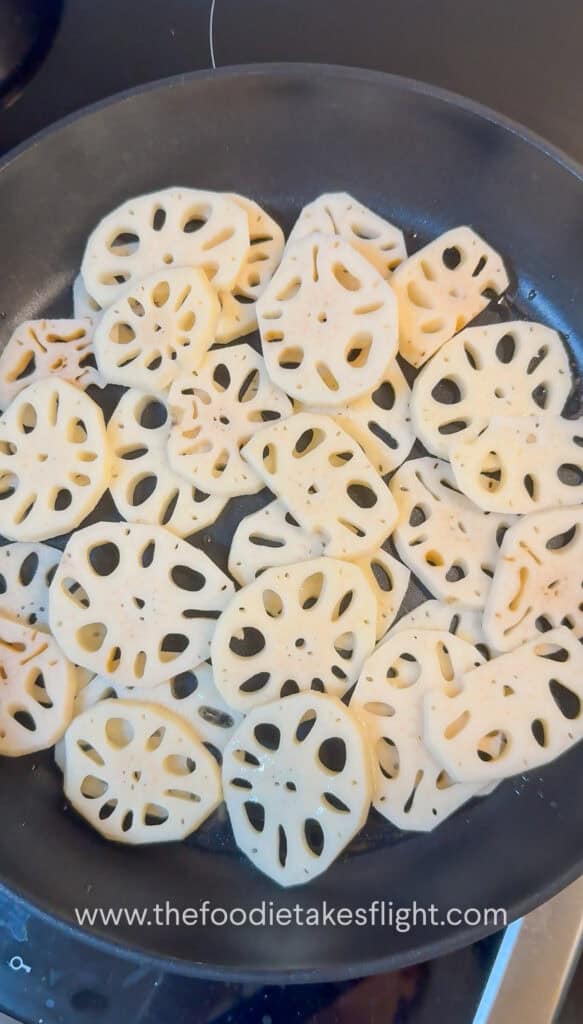 Lotus root browning in a skillet until golden and crisp