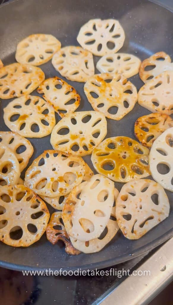 Lotus root browning in a skillet until golden and crisp