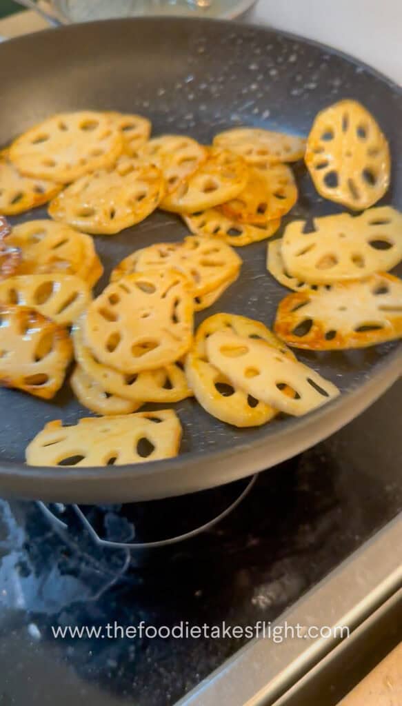 Lotus root browning in a skillet until golden and crisp