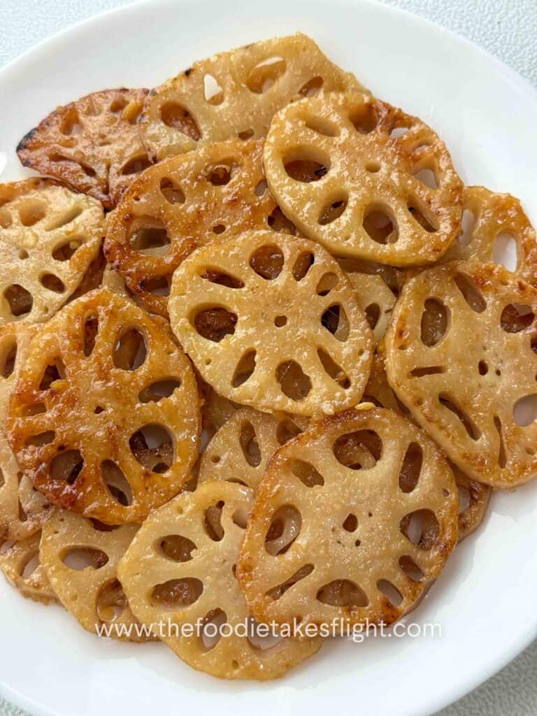 Pan-fried lotus root slices coated in lemon miso sauce and topped with sesame seeds