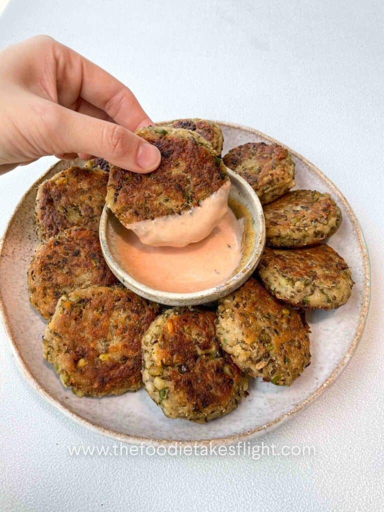 Plate of golden brown pan-fried mung bean patties served with dipping sauce