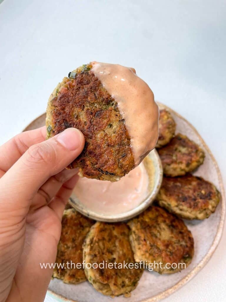 Plate of golden brown pan-fried mung bean patties served with dipping sauce
