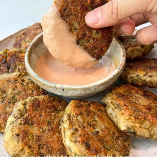 Plate of golden brown pan-fried mung bean patties served with dipping sauce
