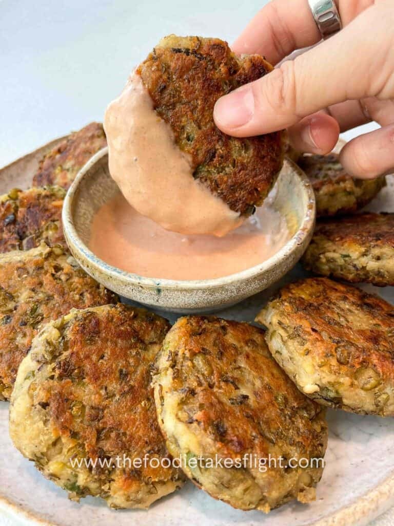 Plate of golden pan-fried mung bean patties served with dipping sauce