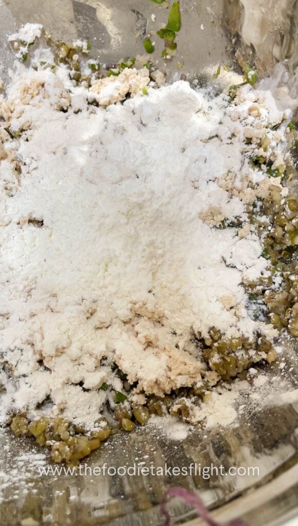 Mung bean and tofu mixture being mixed in a bowl before shaping into patties