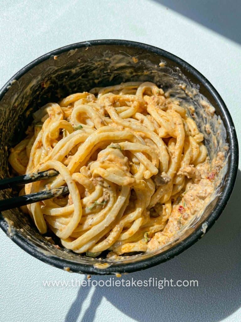 Udon noodles coated in a rich, creamy silken tofu sauce with tofu crumble 