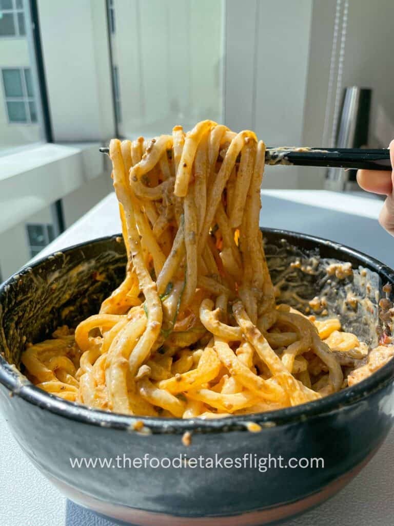 Udon noodles coated in a rich, creamy silken tofu sauce with tofu crumble