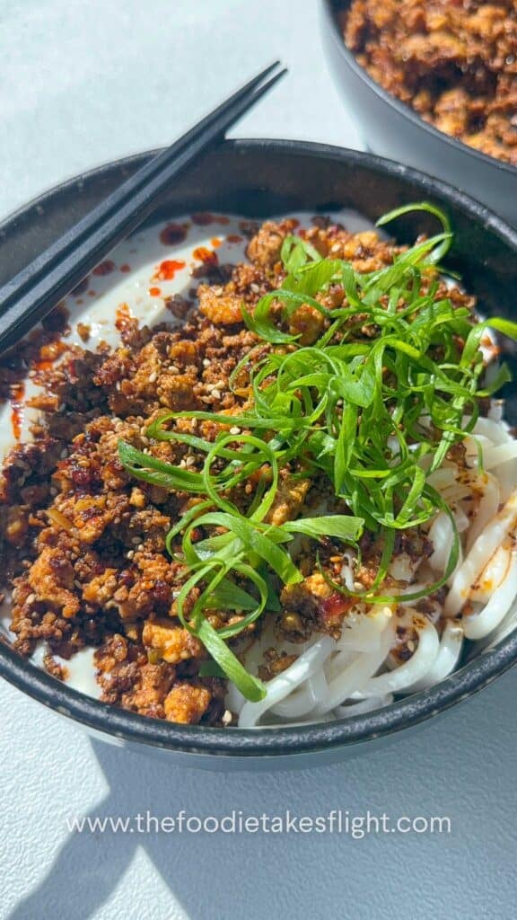 These Creamy Mapo Tofu Udon Noodles are inspired by the viral TikTok trend that combines silky tofu with bold, spicy mapo tofu flavors. This vegan version brings together chewy udon noodles, crumbled tofu cooked in a savory-spicy sauce, and a smooth silken tofu base that makes this whole dish so creamy and satisfying. The dish layers different textures and flavors—you have the crumbled tofu, spicy and numbing Sichuan aromatics, and a silky tofu sauce poured over chewy udon noodles. Finished this with chili oil, scallions, and toasted sesame seeds, and mix everything together. This bowl is comforting, spicy, and deeply satisfying!