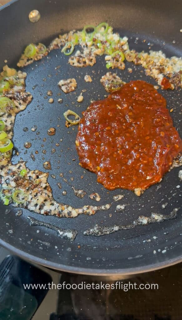 Doubanjiang and Sichuan pepper being cooked with aromatics