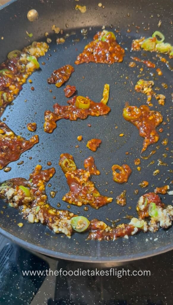 Doubanjiang and Sichuan pepper being cooked with aromatics