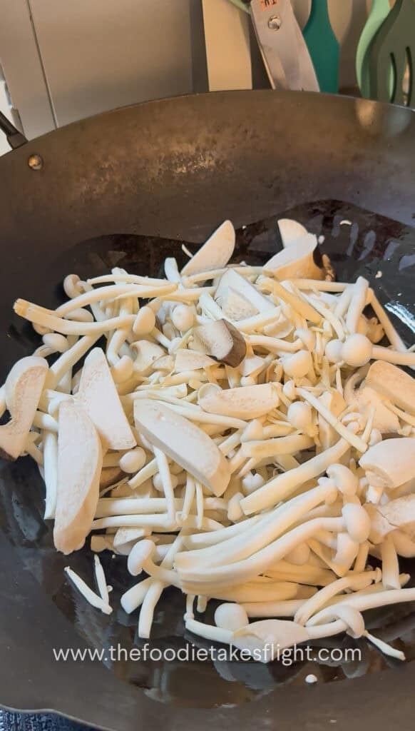 King oyster and shimeji mushrooms cooking in a hot pan until lightly browned