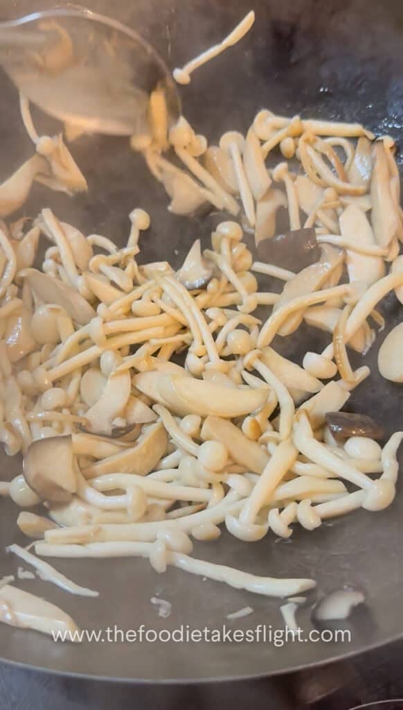 King oyster and shimeji mushrooms cooking in a hot pan until lightly browned