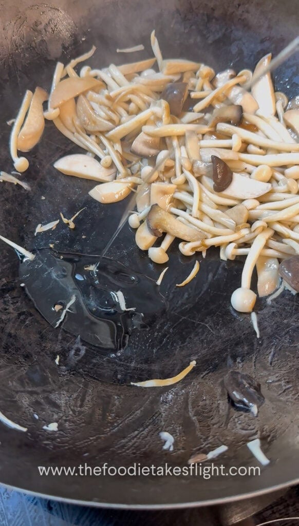 King oyster and shimeji mushrooms cooking in a hot pan until lightly browned