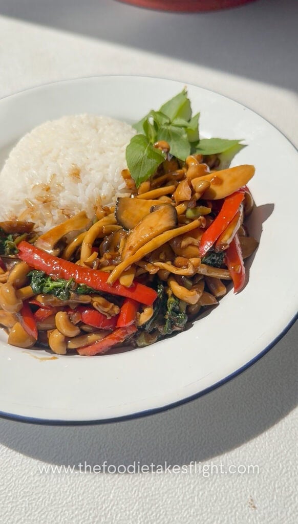Mushroom kra pao stir-fry with mixed mushrooms, chili, garlic, and basil in a rich savory sauce served with rice