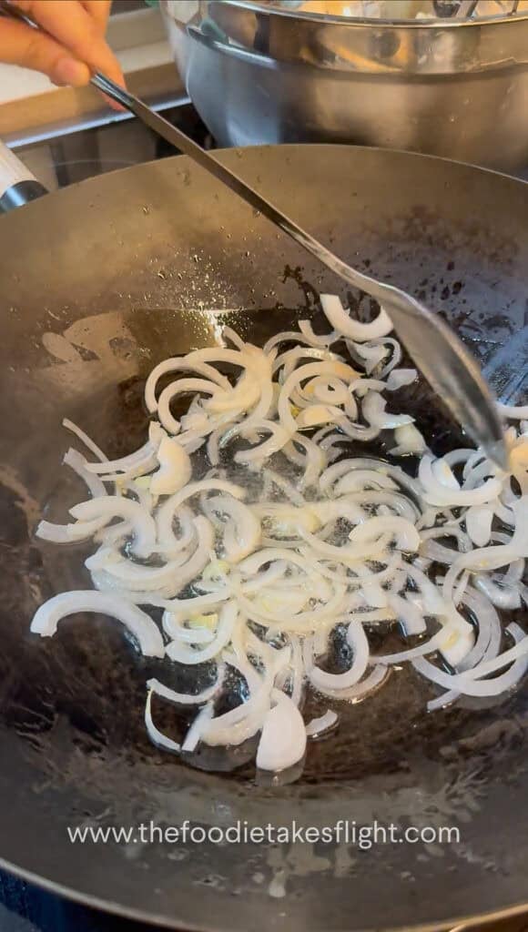 stir-frying aromatics in a steel wok