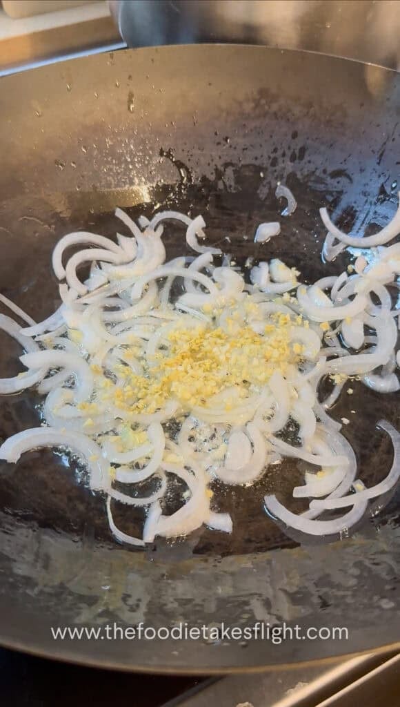 stir-frying aromatics in a steel wok
