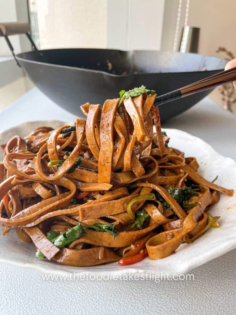 stir-fried beancurd sheets served in a wok with cilantro