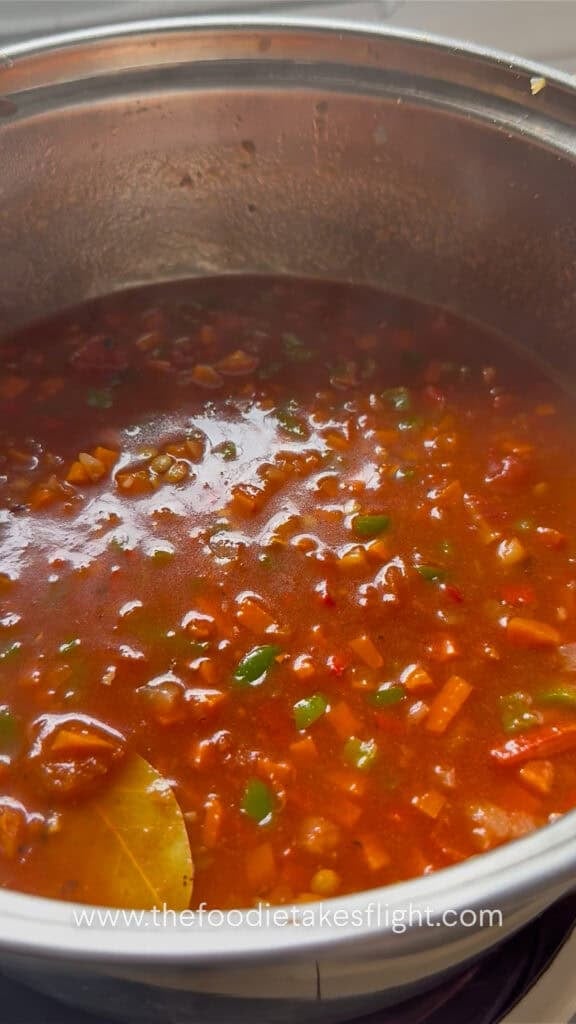 Lentil soup simmering in a pot until the lentils are tender.