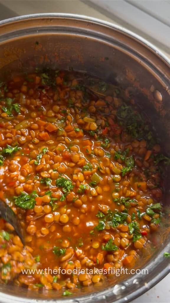 Close-up of hearty lentil soup with parsley, carrots, and lentils in a pot