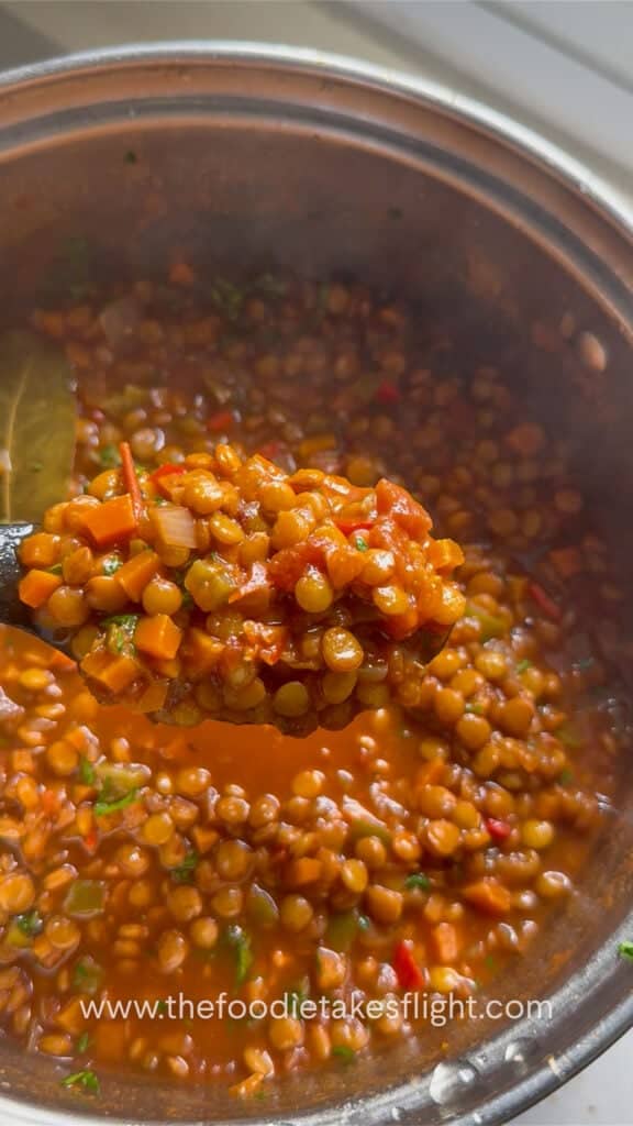 Close-up of hearty lentil soup with parsley, carrots, and lentils in a pot