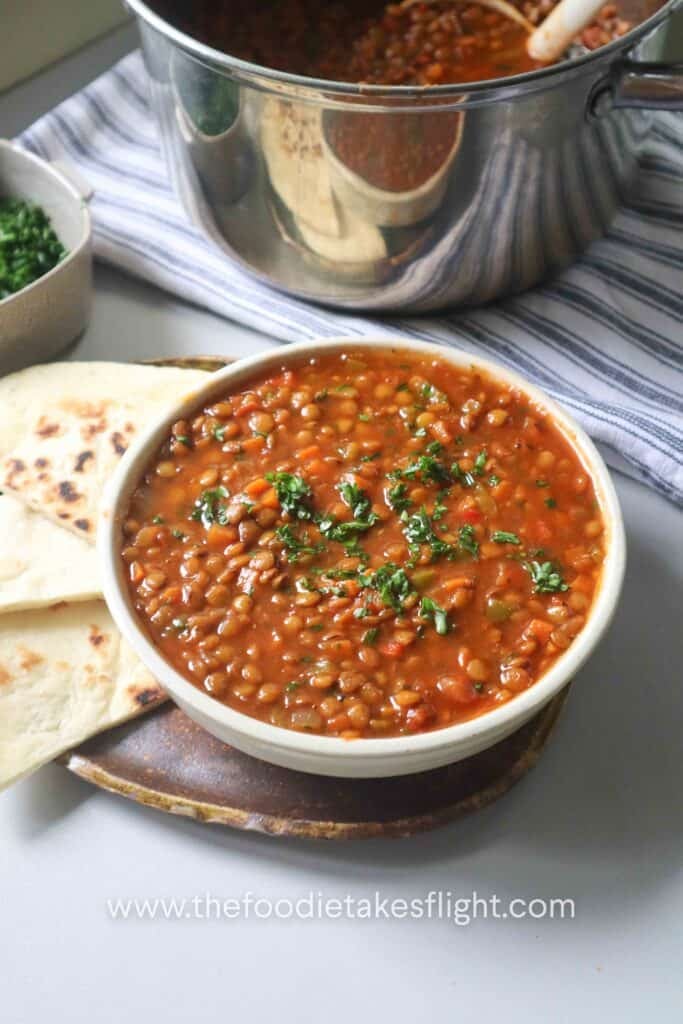Close-up of hearty lentil soup with parsley, carrots, and lentils in a pot