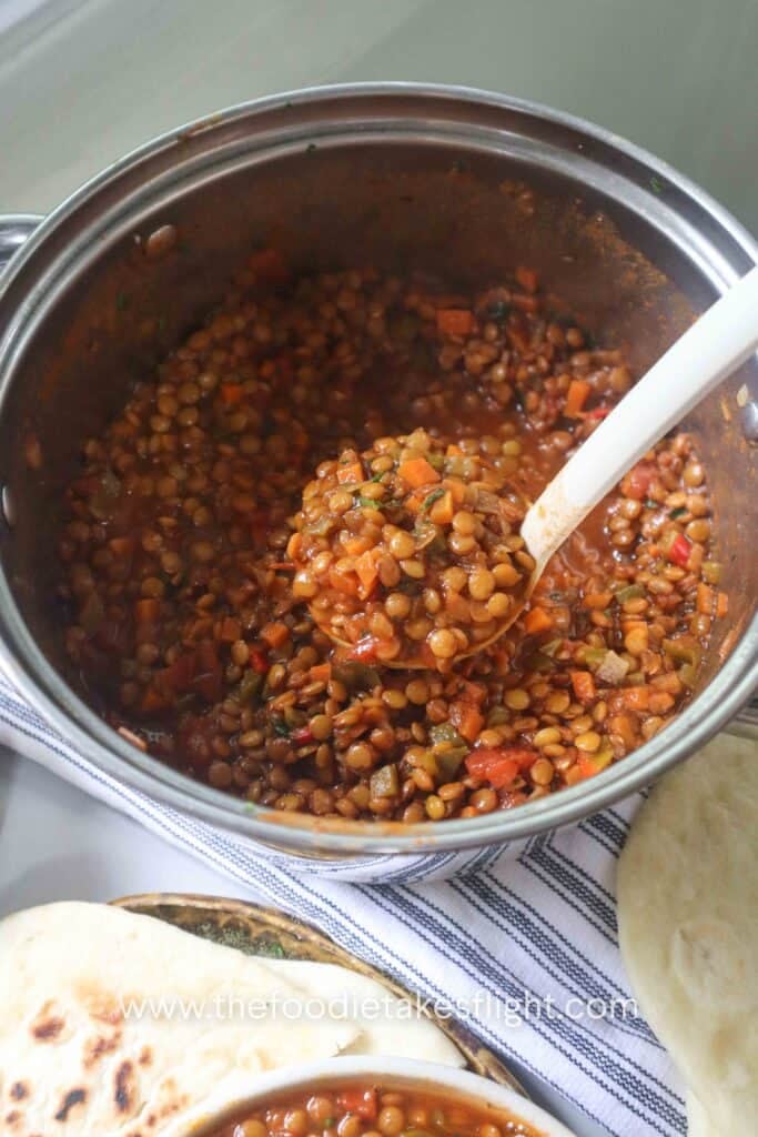 scooping lentil soup from the pot