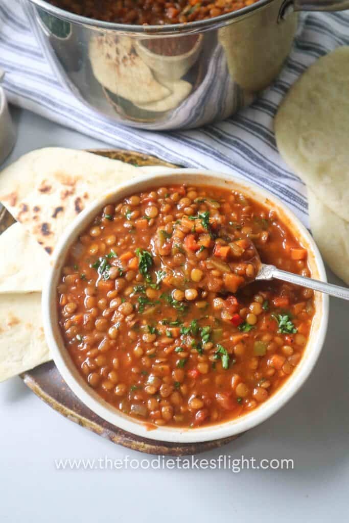 hearty one-pot lentil soup in a bowl served with homemade pita