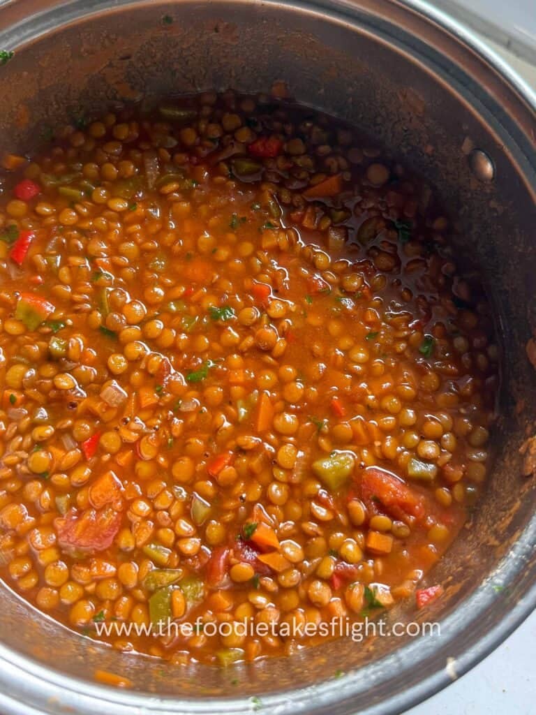 Close-up of hearty lentil soup with parsley, carrots, and lentils in a pot