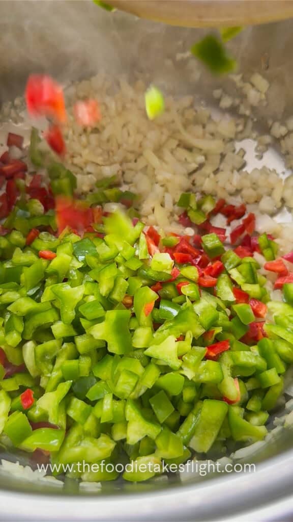 Aromatics and vegetables cooking in a pot for lentil soup.