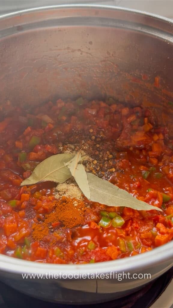 Tomato paste and seasonings added to the sautéed vegetables.