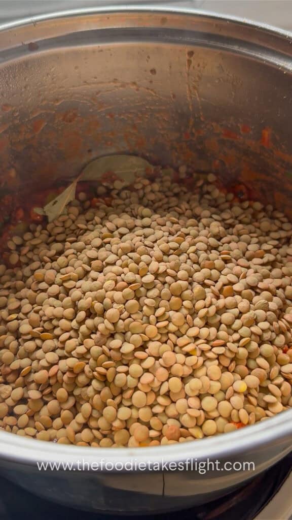 Dried lentils added to the pot with the cooked vegetables.