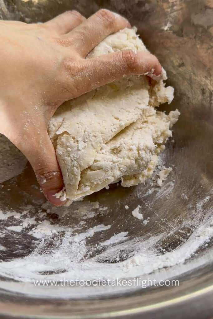 Homemade pita dough being kneaded until smooth, soft, and elastic