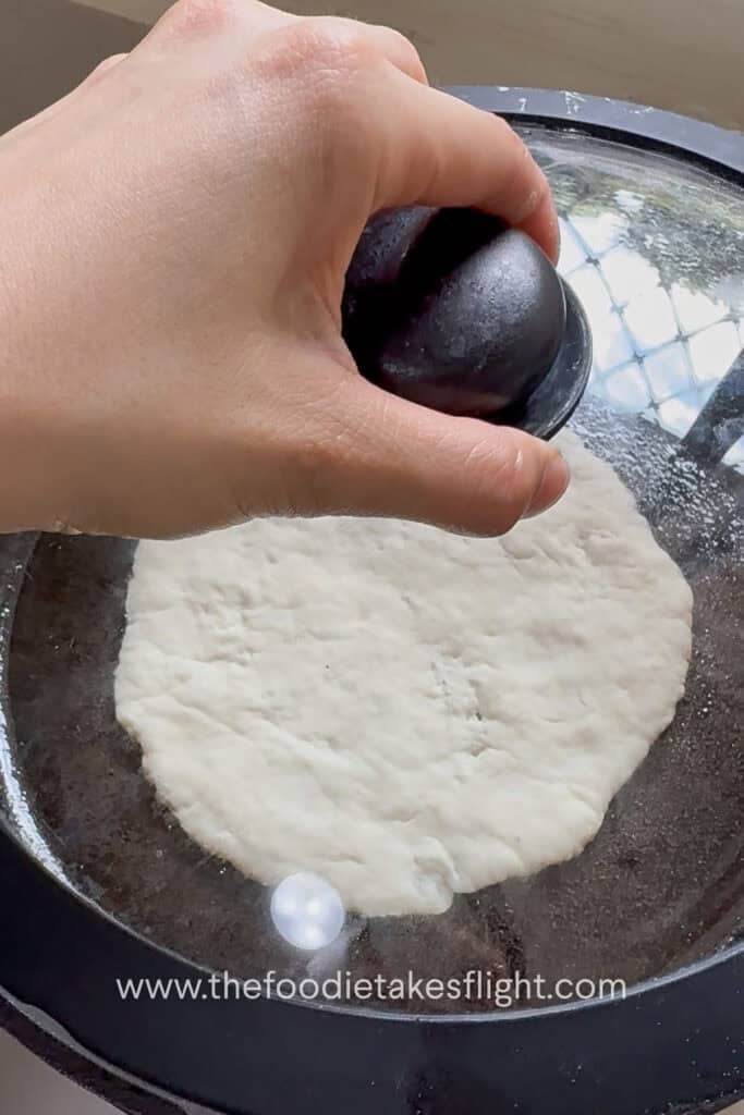 covering the pan to allow pita to cook