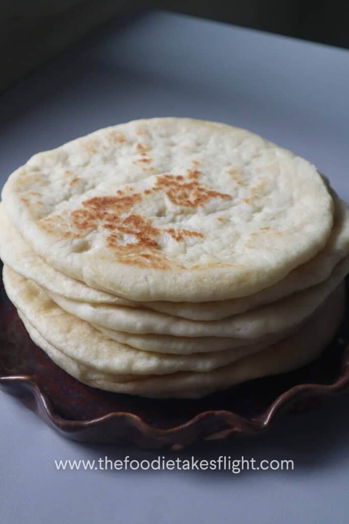a stack of soft fluffy pita bread on a plate