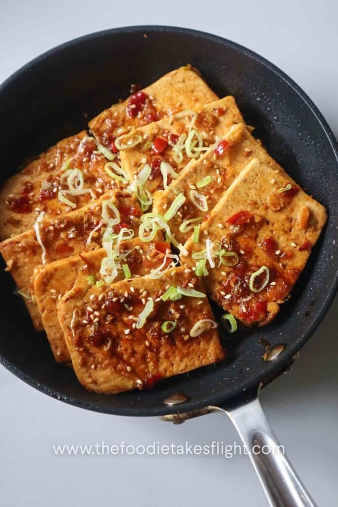 one-pan sweet and spicy tofu served with scallions and sesame seeds