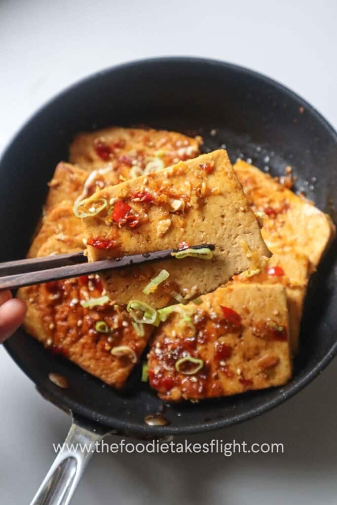 one-pan sweet and spicy tofu served with scallions and sesame seeds