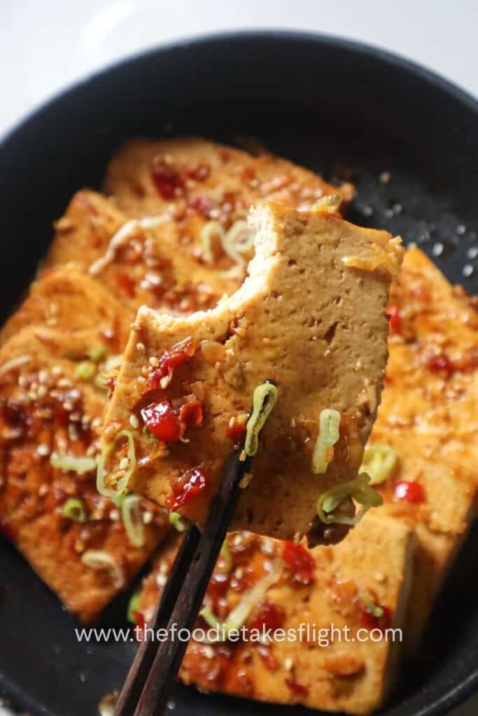 one-pan sweet and spicy tofu served with scallions and sesame seeds