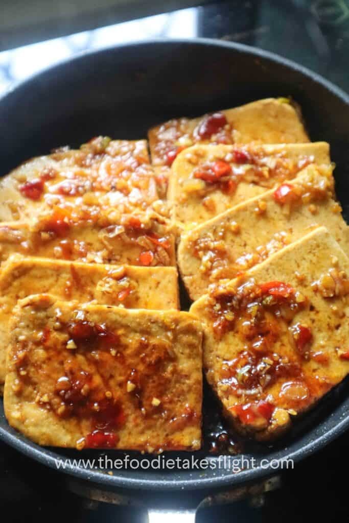one-pan sweet and spicy tofu served with scallions and sesame seeds