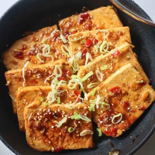 one-pan sweet and spicy tofu served with scallions and sesame seeds