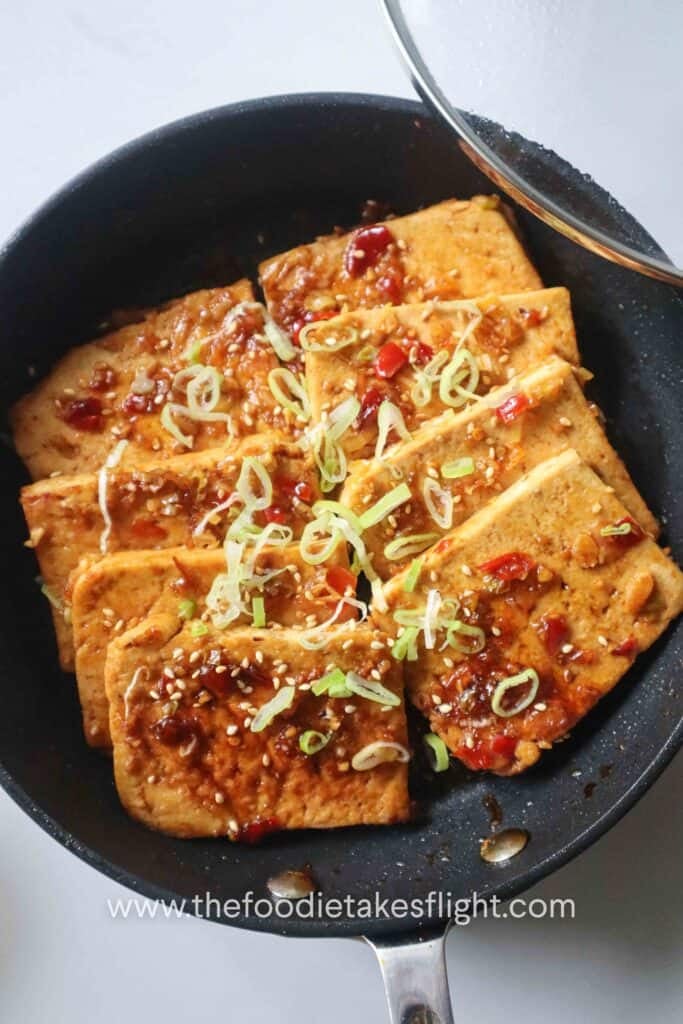 one-pan sweet and spicy tofu served with scallions and sesame seeds