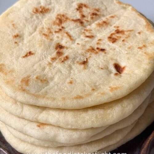 Easy homemade pita bread stacked on a plate with soft, fluffy texture and golden brown spots
