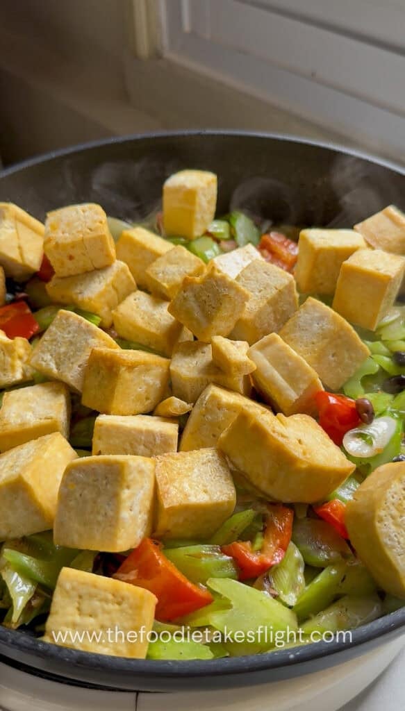Golden tofu added back to the pan with the stir-fried celery and bell pepper
