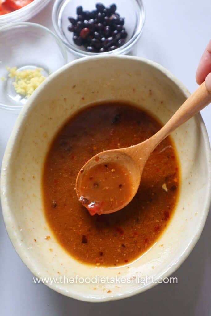 Vegetarian oyster sauce, soy sauce, ketchup, sugar, Chinese black vinegar, chili oil, water, and cornstarch mixed in a bowl