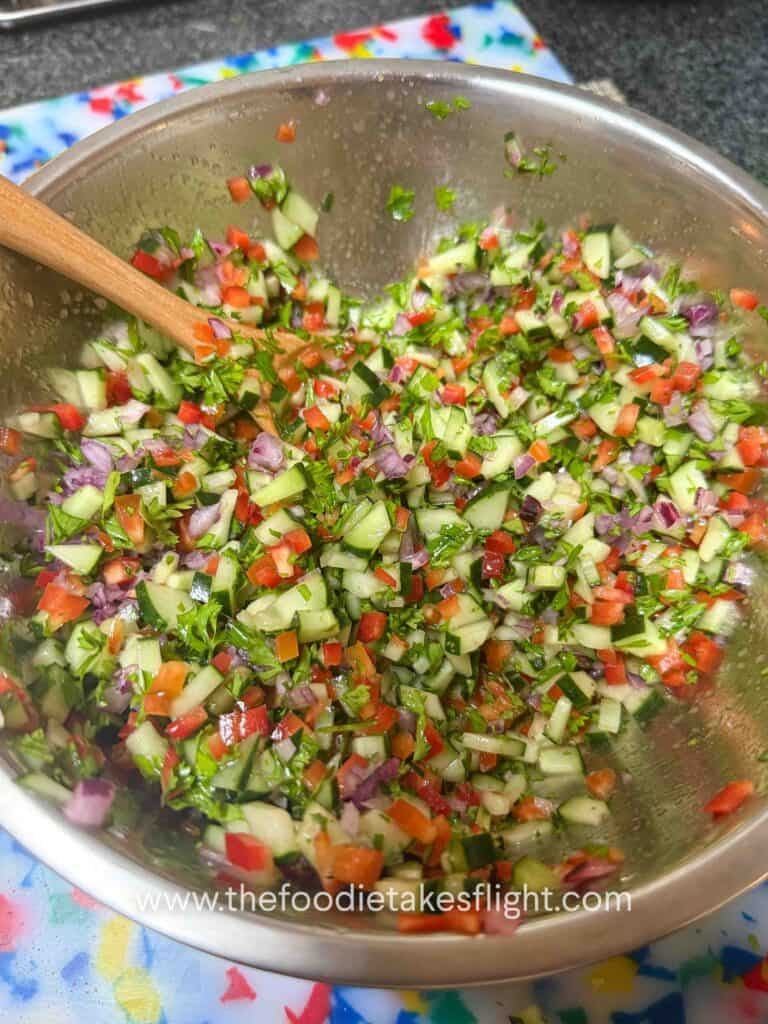 Chopped cucumber, red bell pepper, red onion, and parsley salad for pita wraps