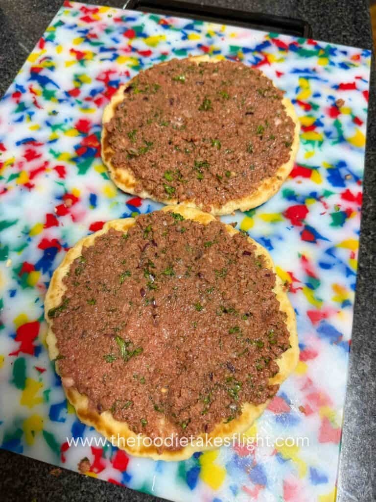 Seasoned Impossible meat spread onto the open side of pita bread before cooking