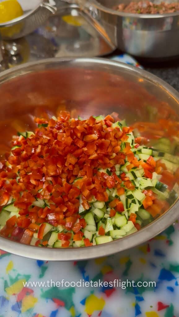 Chopped cucumber, red bell pepper, red onion, and parsley salad for pita wraps